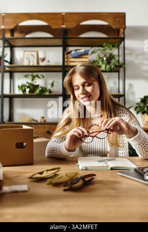 Une jeune femme trie soigneusement ses vêtements et accessoires, en se concentrant sur la durabilité et le don. Banque D'Images