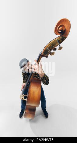 Le bassiste Rockstar pliant les cordes avec intensité, entièrement immergé dans un moment musical rebelle et puissant. Banque D'Images