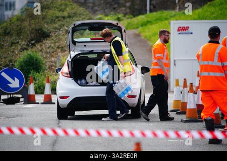 Photo du dossier datée du 17/05/24 de personnes ramassant de l'eau embouteillée au parking Freshwater à Brixham. Pennon, propriétaire de South West Water, a révélé un impact d'environ 16 millions de livres sterling de l'épidémie de parasites dans le Devon plus tôt cette année. Date d'émission : jeudi 26 septembre 2024. Banque D'Images