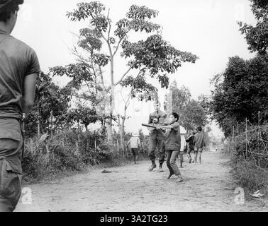 Des membres du 3e bataillon américain, du 187e d'infanterie, de la 101e division aéroportée (Airmobile), rejoignent des enfants dans le jeu de baseball, AP Uu Thoung, Vietnam, U.S. Army signal corps, 15 janvier 1970 Banque D'Images