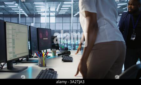 Les ingénieurs voient un message contextuel piraté sur l'écran du PC dans le centre de données, demandant l'aide de l'équipe de cybersécurité. Employé de la ferme de serveurs constatant des incidents de sécurité affectant le système réseau, caméra A. Banque D'Images
