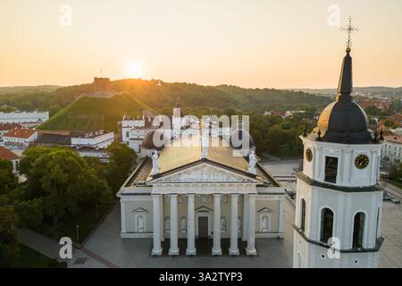 Vue aérienne de la cathédrale de Vilnius avec le clocher et le château de Gediminas sur la colline au lever du soleil Banque D'Images