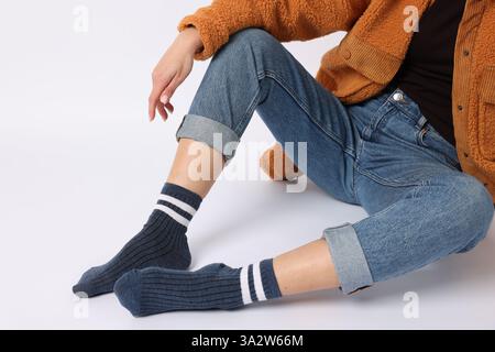 Femme portant des chaussettes bleues sur fond blanc, gros plan Banque D'Images