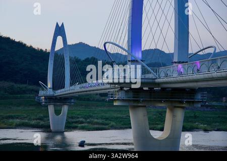 Comté de Gurye, Corée du Sud - 3 octobre 2021 : une vue détaillée du pont Toad montre sa structure illuminée au crépuscule, enjambant la rivière Seomjin. Banque D'Images