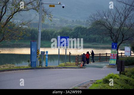 Comté de Gurye, Corée du Sud - 3 octobre 2021 : un groupe de personnes se tient près de l'entrée de la piste cyclable Seomjingang, surplombant les eaux calmes de Banque D'Images