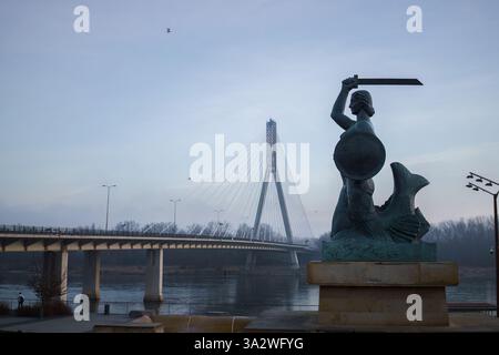 Varsovie, Pologne. 27 janvier 2025 - Statue de Sirène avec le pont Swietokrzyski en arrière-plan, tôt le matin. Banque D'Images