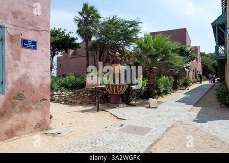 Dakar, Sénégal – vue sur la rue de l’île de Gorée, avec son architecture coloniale et le Monument à l’abolition de l’esclavage, un site classé au patrimoine de l’UNESCO. Banque D'Images