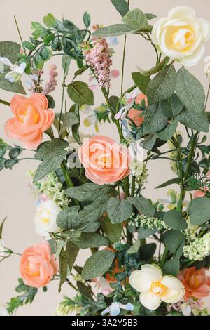 Un gros plan de fleurs artificielles pastel douces disposées décoratives Banque D'Images