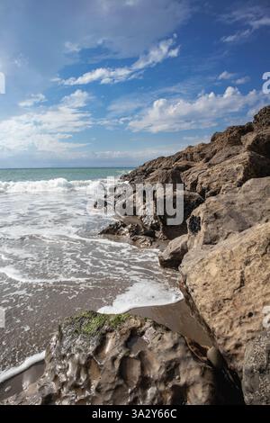 Les vagues s'écrasent contre les rivages rocheux, le ciel bleu vif à Ventura Beach. Banque D'Images