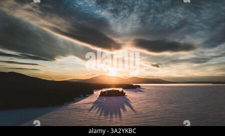 Spectaculaire vue aérienne du coucher du soleil sur le lac Moosehead gelé d'hiver, dans le Maine Banque D'Images
