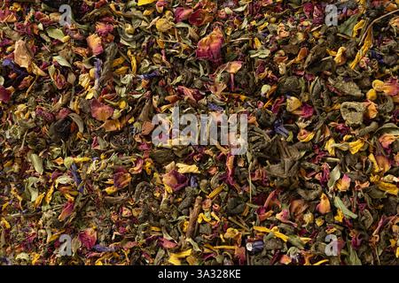 Divers types de thé de fleurs à base de plantes sèches et de thé vert. Vue de dessus. Texture des feuilles de thé sèches et fond abstrait. Banque D'Images