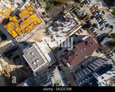 Le site de construction présente des matériaux et des équipements vibrants sous la lumière du soleil dans une zone urbaine. Vue aérienne de haut en bas Banque D'Images