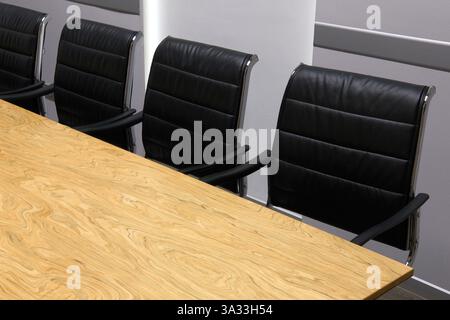 Intérieur de salle de conférence vide, salle de réunion, salle de réunion, salle de classe, bureau avec chaises en cuir noir et table en bois. Banque D'Images