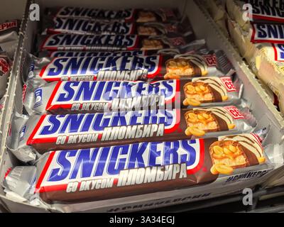 Bobruisk, Biélorussie - 2 mars 2025 : plusieurs bonbons Snickers sont soigneusement disposés sur les étagères d'un dépanneur animé. Banque D'Images
