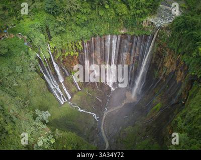Une photo aérienne capture la superbe cascade de Tumpak Sewu en pleine gloire, mettant en vedette plusieurs cascades sur des falaises verdoyantes. Banque D'Images