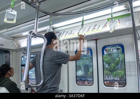 L'intérieur d'un train RapidKL Scomi SUTRA à Kuala Lumpur, en Malaisie, avec des navetteurs à bord Banque D'Images