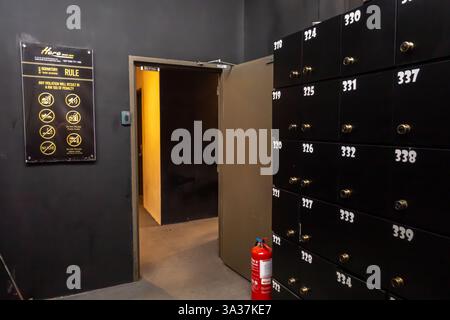 mur avec des casiers numérotés de 110 à 119, une porte ouverte à une autre chambre un extincteur près de la porte, et l'ensemble des règles, hôtel Banque D'Images
