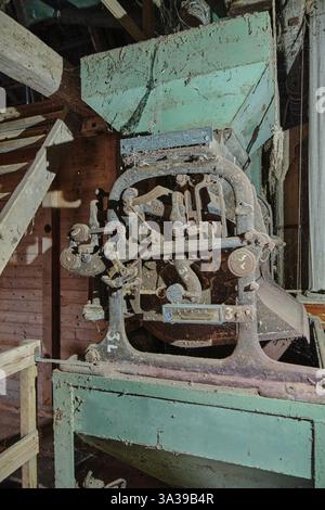 12 mars 2025 - Hoya-Allemagne : vieille échelle de gravité de grain dans un moulin à eau historique, recouverte de rouille, de poussière et de toiles d'araignée, avec des pièces métalliques corrodées. Banque D'Images