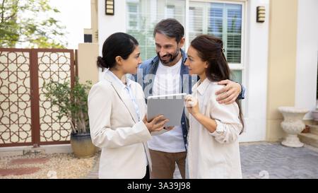 Heureux couple rencontre avec la femme agent immobilier à l'hébergement Banque D'Images