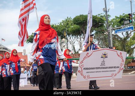 Des employées de la Malacca public Library Corporation portant le foulard rouge, défilant lors du défilé de la fête nationale à Malacca, en Malaisie Banque D'Images
