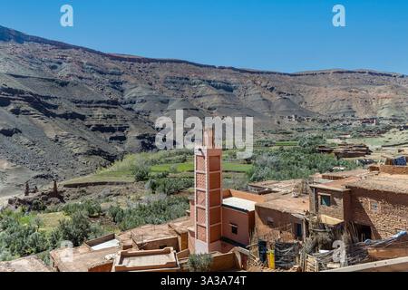 Paysage d'une mosquée marocaine traditionnelle sur l'autoroute et montagnes enneigées de l'Atlas. Prise à Timedline, province d'Ouarzazate, Maroc Banque D'Images