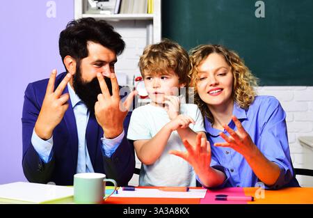 Enfant garçon en classe étudier les mathématiques avec les enseignants et compter sur les doigts. Mathématiques pour les enfants à l'école. Un élève d'écolier qui fait des maths chez lui Banque D'Images