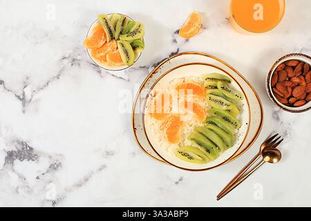 Petit déjeuner sain avec des ingrédients, pudding de riz avec kiwi, miel, mandarines et amandes.plat, concept alimentaire sain et naturel, style de vie, nourriture Banque D'Images