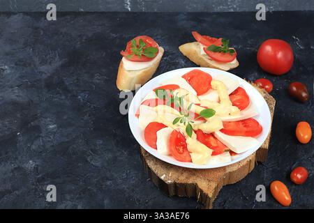 Caprese et toast bruschetta avec mozzarella, tomates cerises et basilic frais du jardin. Cuisine italienne traditionnelle, petit déjeuner naturel sain, chol Banque D'Images