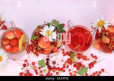Boissons estivales, jus de fraise et de groseille avec baies. Délicieuse limonade molle de groseilles et de fraises sur un fond rose, vue de dessus, copie Banque D'Images