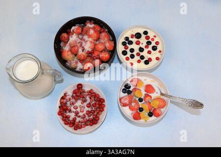 Yaourt aux fraises, lait et baies mûres de groseilles et fraises sur un fond clair. Délicieux petit déjeuner sain de yaourt et fraises wi Banque D'Images