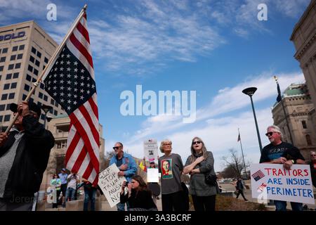 Un vétéran du Vietnam, à gauche, tient un drapeau américain à l'envers en signe de détresse tandis que les vétérans de l'armée américaine et leurs partisans protestent contre les coupes de l'administration Trump dans le département des anciens combattants (va) et d'autres changements affectant les vétérans et l'armée à l'extérieur de l'Indiana Statehouse à Indianapolis. La protestation populaire non officielle a été déclenchée par un dépliant posté par le mouvement 50501 et découvert en ligne par des vétérans à travers les États-Unis. Des marches de vétérans ont également eu lieu à Washington, DC, et dans d'autres capitales d'État à travers le pays. Banque D'Images