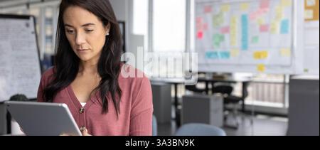 Gestionnaire de démarrage en ligne travaillant avec une tablette dans le coworking de bureau Banque D'Images