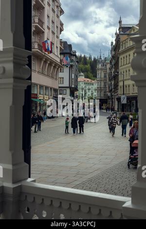 Une rue piétonne animée de Karlovy Vary, en République tchèque, est bordée de bâtiments historiques, de boutiques et de cafés, où les touristes et les habitants se promènent dans la célèbre ville thermale. Banque D'Images