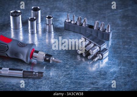 Jeu d'outils de tournevis avec embouts remplaçables en acier inoxydable et torx sur fond métallique rayé concept de construction Banque D'Images