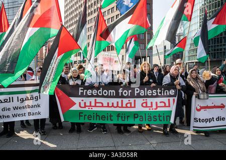Berlin, Berlin, Allemagne. 15 mars 2025. Des manifestants pro-palestiniens se sont rassemblés sur Potsdamer Platz dans le centre de Berlin le samedi 15 mars 2025, agitant des drapeaux palestiniens et portant des keffiyehs traditionnels pour exiger la libération immédiate de Mahmoud Khalil, un activiste palestinien détenu par les autorités américaines de l'immigration. La manifestation, organisée en solidarité avec les anciens étudiants de l'Université Columbia, a mis en évidence l'indignation internationale croissante à propos de son arrestation et de sa détention continue. La manifestation comportait un discours de Cameron Jones, étudiant et militant de l'Université Columbia, qui a appelé à la mise en œuvre immédiate de Khalil Banque D'Images