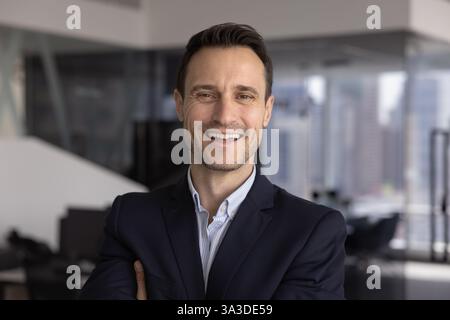 Heureux homme d'affaires confiant regardant la caméra avec le sourire dentelé Banque D'Images
