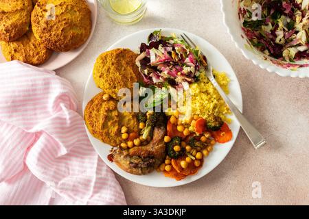Un petit déjeuner sain avec des crêpes lentilles-courgettes, du millet, du cou de poulet rôti, des patates douces, du brocoli, carottes, pois chiches et salade fraîche mélangée avec des radis, des noix et des germes de haricots mungo Banque D'Images