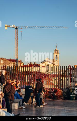 Lisbonne, Portugal - 2 janvier 2025 : les gens au Miradouro de Santa Catarina apprécient le coucher de soleil sur Lisbonne Banque D'Images