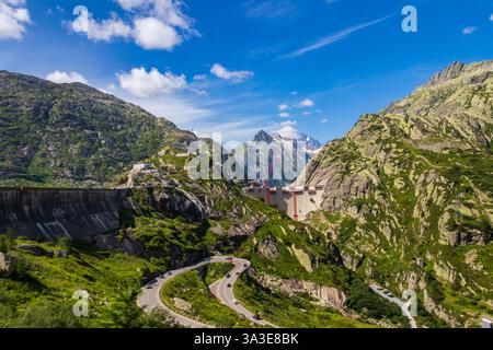 Vue panoramique du chantier de construction avec grues rouges du nouveau barrage au col de montagne suisse Grimsel Banque D'Images