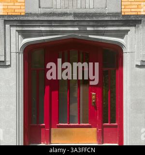 Une porte rouge audacieuse de style Art déco sertie dans une élégante façade en pierre, avec des éléments géométriques à Chicago Banque D'Images