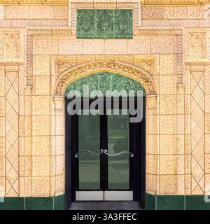 Une entrée ornée à double porte encadrée par des détails architecturaux verts complexes sur un bâtiment historique en terre cuite à Chicago. Banque D'Images