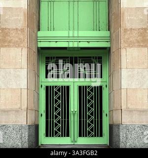Porte Art déco ornée de métallurgie géométrique symétrique en vert menthe, encadrée par des murs en pierre sur une façade de bâtiment historique de Chicago Banque D'Images