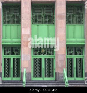 Façade de bâtiment Art déco avec des portes géométriques vert menthe frappantes, des fenêtres et des détails métalliques, Chicago. Banque D'Images