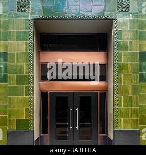 Entrée art déco carrelée verte avec accents de cuivre dans un bâtiment historique de Chicago. Banque D'Images