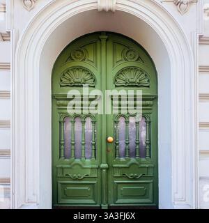 Élégante porte double voûtée verte avec des sculptures en bois complexes à Kraków, Pologne Banque D'Images