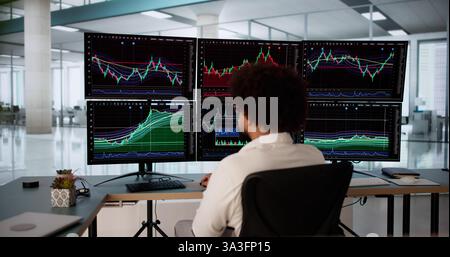 Courtier boursier afro-américain analysant des graphiques sur plusieurs écrans. , courtier, analyste financier, agent boursier. Banque D'Images