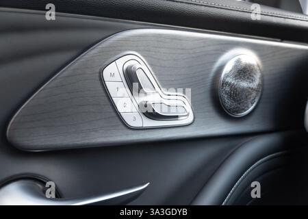 Poignée de porte avec boutons de commande de siège électrique d'une voiture de tourisme de luxe. Intérieur en cuir noir de la voiture moderne de luxe. Détails intérieurs de voiture modernes Banque D'Images