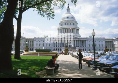 Vue est de Capitol Hill par une chaude journée de printemps ensoleillée en mai. Quelques visiteurs devant ce bâtiment historique symbolique. Washington DC. Vieilles voitures américaines et européennes garées dans la rue. États-Unis, en 1984 sur le film Kodak EKTACHROME. Banque D'Images