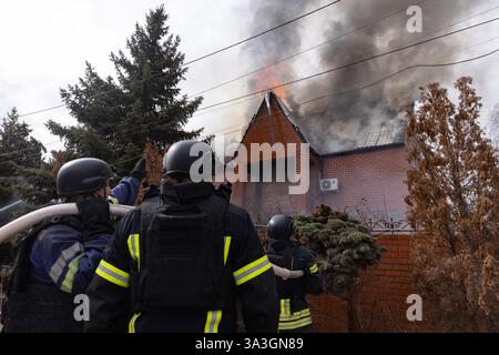 Des pompiers éteignent un incendie causé par un drone russe frappant une maison privée, dans la région de Donetsk, en Ukraine, le 15 mars 2025. L'armée russe a effectué un autre bombardement de la périphérie de la ville de Kostyantynivka, rapporte le MVA. L'ennemi a poursuivi ses attaques en utilisant un véhicule aérien sans pilote de type Molniya-1. À la suite de la frappe d'une zone résidentielle, la façade d'une maison privée a été endommagée. Heureusement, il n'y a pas eu de victimes parmi la population civile. Photo de Yevhen Titov/AABACAPRESS. COM Banque D'Images