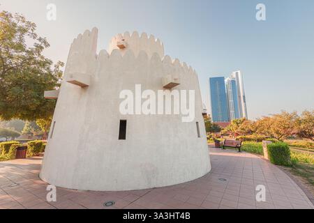 15 janvier 2025, Abu Dhabi, eau : vieille tour de guet debout sur fond de gratte-ciel modernes dans le parc à Abu Dhabi Banque D'Images